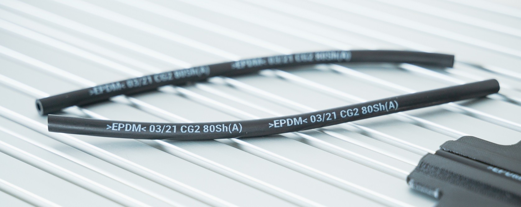 EPDM plast potištěný bílým inkoustem z cartridge tiskárny TS Electronics, který je UV LED světlem zesíťovany polymer, který je odolný na chemii a velmi odolává i otěru.